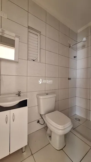 Foto de um banheiro com revestimento cerâmico branco.