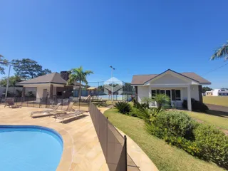 Vista externa da propriedade mostrando a piscina e o jardim.
