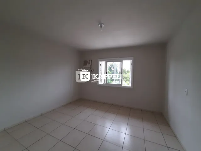 Uma sala de estar vazia com piso de cerâmica e janela.