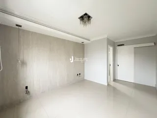 Interior de uma sala ampla com piso claro e paredes texturizadas.