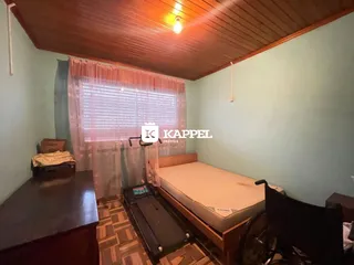 Quarto com cama de casal e cabeceira de madeira em um apartamento.