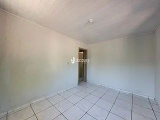 Interior de um cômodo com paredes brancas e piso de cerâmica.