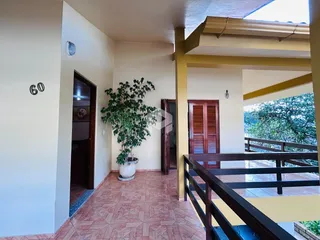 Hall de entrada com piso de cerâmica em tons terrosos e porta de entrada.