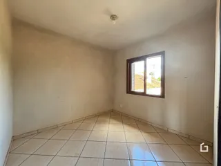 Hall de entrada com piso de cerâmica e paredes brancas.