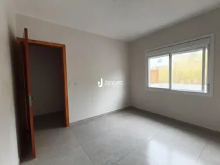Interior de uma sala com piso de cerâmica e uma porta de entrada.