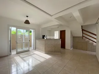 Sala de estar com piso de cerâmica e teto inclinado.