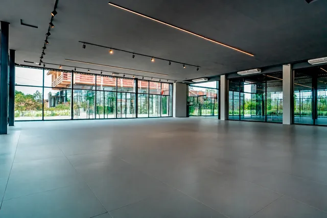 Espaço interno amplo com grandes janelas de vidro em um imóvel.