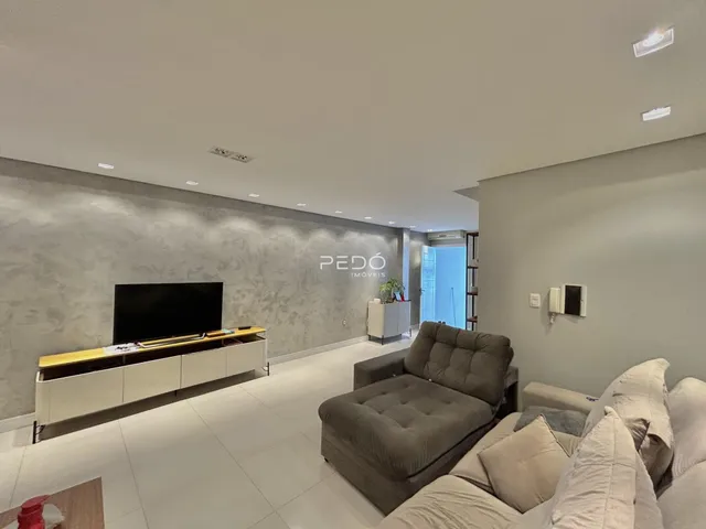 Sala de estar moderna com sofá e televisão em um apartamento.