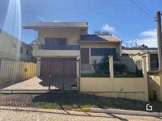 Fachada de uma residência em Lajeado, Brasil, com portão e cerca.