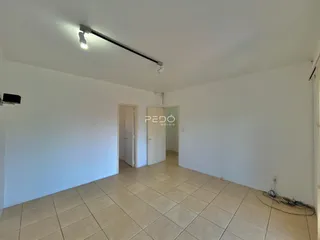 Interior de uma sala com piso de cerâmica clara e paredes brancas.