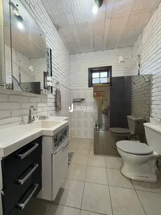 Foto de um banheiro com revestimento de azulejo branco.