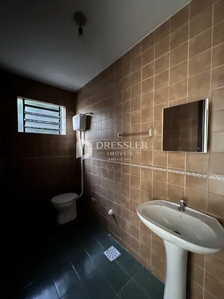 Foto de um banheiro com revestimento de azulejos marrons.