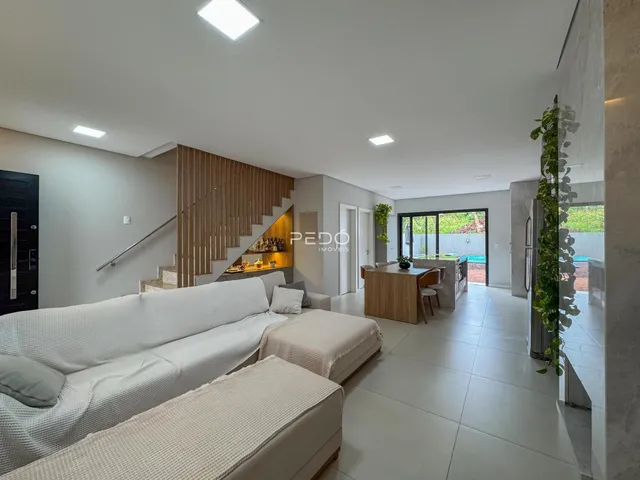Sala de estar moderna com sofá e piso de cerâmica em um imóvel no Brasil.