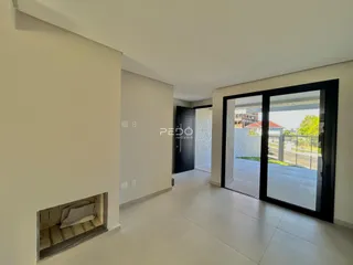 Hall de entrada com paredes brancas e piso claro.