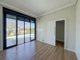 Sala de estar com portas de vidro que dão acesso a uma área externa com piscina.