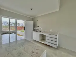 Vista interna de uma cozinha com bancada e portas de vidro.