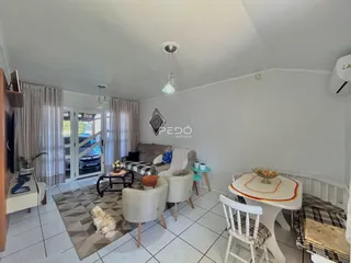 Sala de estar com sofá e mesa de jantar em um imóvel no Brasil.