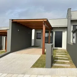 Fachada de uma residência com cobertura de madeira na entrada.