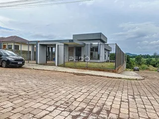 Fachada de uma residência em Lajeado, Brasil, com cerca e área pavimentada na frente.
