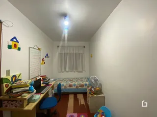 Quarto interno com janela e cortinas brancas.