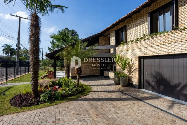 Fachada de uma residência em Lajeado, Brasil, com jardim e entrada pavimentada.