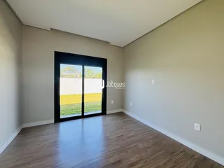 Sala de estar com piso de madeira e porta de vidro voltada para o jardim.