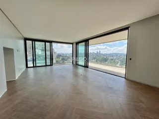 Sala de estar ampla com piso de madeira e vista da paisagem urbana.
