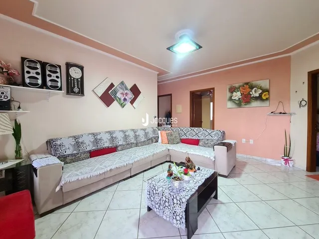 Sala de estar com sofá e piso claro em um imóvel no Brasil.