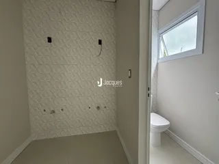Parede de box de banheiro com revestimento branco e piso claro em imóvel em Lajeado.