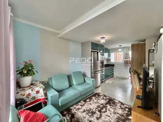 Sala de estar com sofá azul claro e tapete na residência.