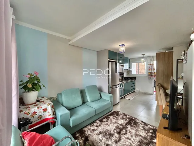 Sala de estar com sofá azul claro e tapete na residência.