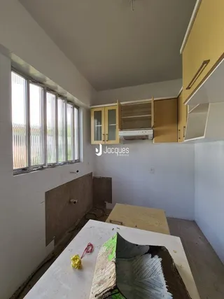 Quarto interno com janela e paredes brancas.