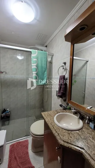 Foto de um banheiro com azulejos brancos e bancada de granito.