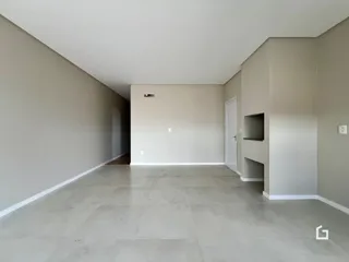 Ambiente interno de uma sala ampla com piso de cerâmica clara.