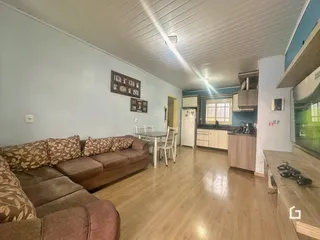 Sala de estar com sofá e mesa de jantar em um apartamento.