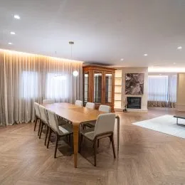 Foto do interior de uma sala com piso de madeira e armários em um imóvel.