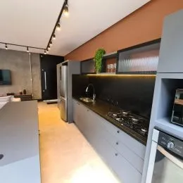 Foto de uma cozinha com armários e bancada escura.
