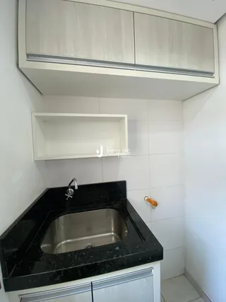 Foto de um banheiro com bancada escura e revestimento branco.