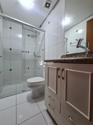 Foto de um banheiro com revestimento cerâmico branco.
