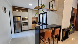 Interior de uma cozinha moderna com armários e ilha em Lajeado.