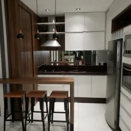 Uma cozinha com armários escuros e bancada clara é visível na propriedade.