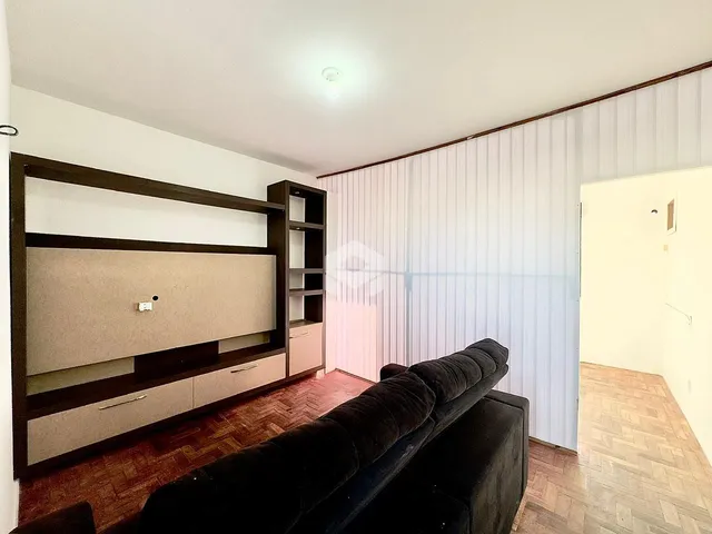 Sala de estar com painel de madeira e sofá escuro.