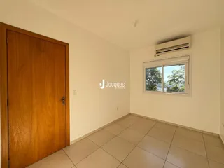 Interior de um cômodo com porta de madeira e piso de cerâmica clara.