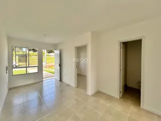 Ambiente interno com piso de cerâmica claro e portas de acesso a outras áreas.