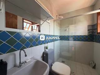 Banheiro com pia, vaso sanitário e box de vidro.