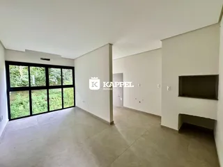 Sala de estar com grande janela que oferece vista para a vegetação externa.