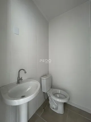 Foto interna de um banheiro com pia e vaso sanitário em cerâmica.