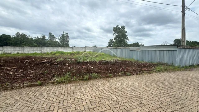 Vista externa mostrando terra e cerca de metal em uma propriedade.