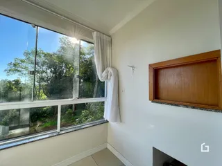 Interior de um cômodo com grande janela de vista para a natureza.