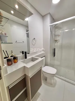 Interior de um banheiro moderno com revestimento branco.